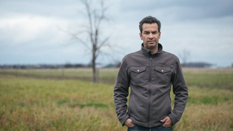 Mark Schatzker na polu porośniętym trawą